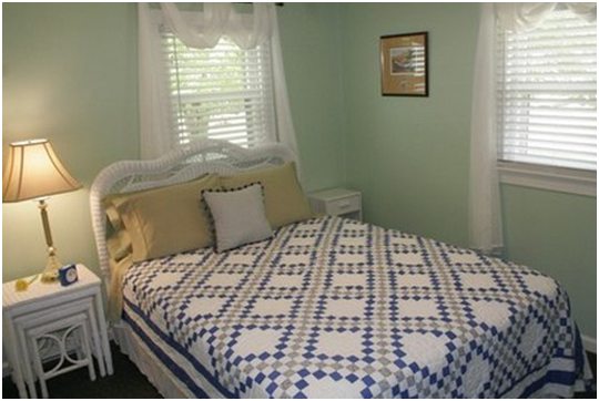 In the quaint and comfortably decorated bedroom, there is a queen bed, a tall chest of drawers, two nightstands, and a chair.  A nice-sized closet offers space for your hanging clothes and shoes.